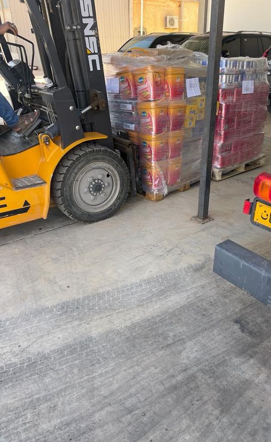 Forklift moving wrapped pallets of goods