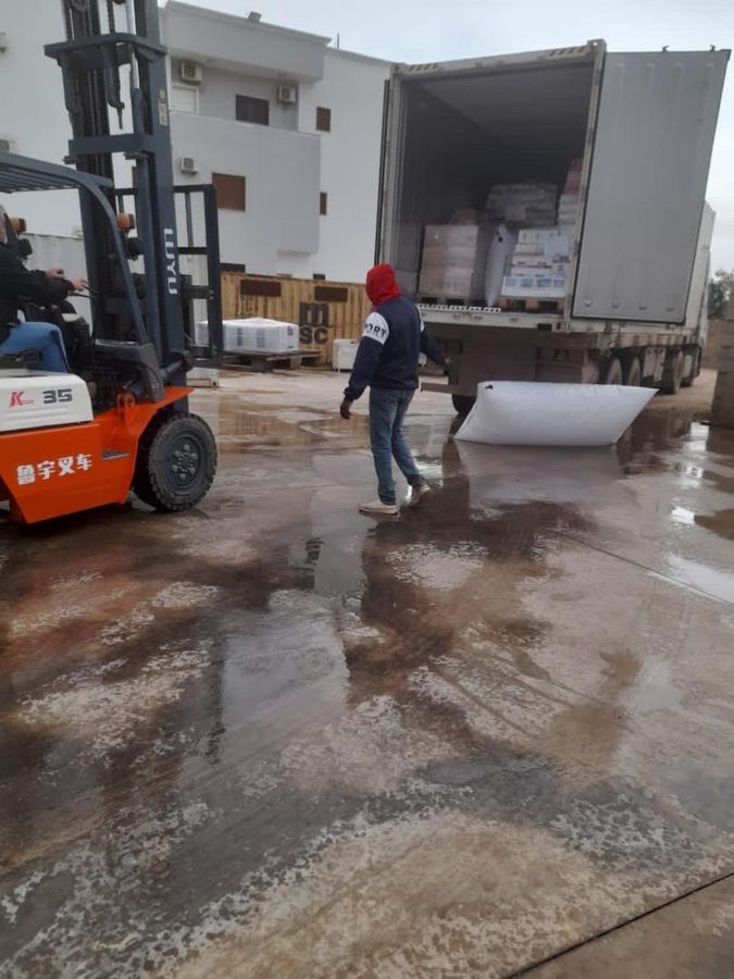 Forklift and crew unloading a container